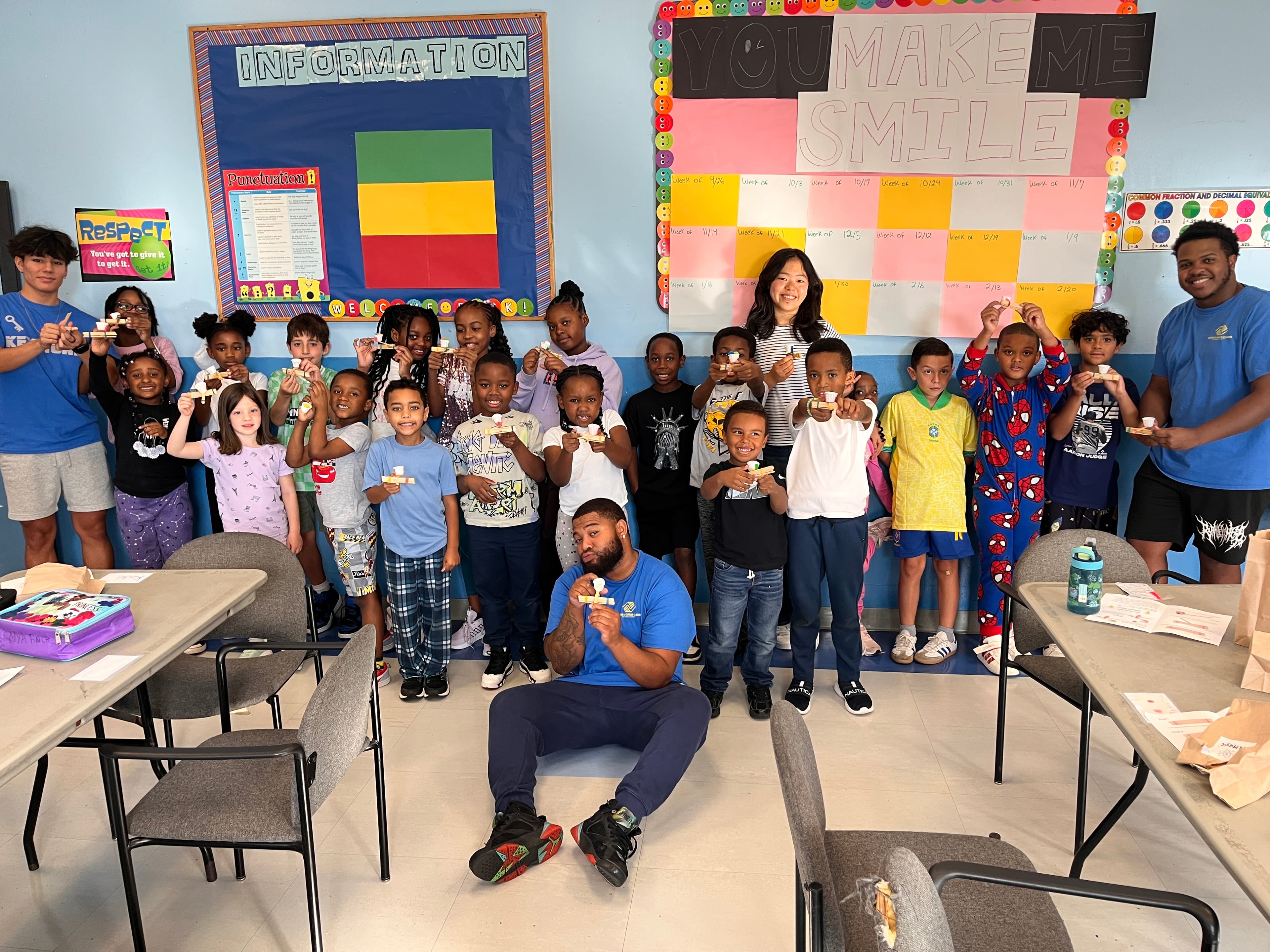 Students at Boys and Girls Clubs of Union County holding up the popsicle stick catapults they built