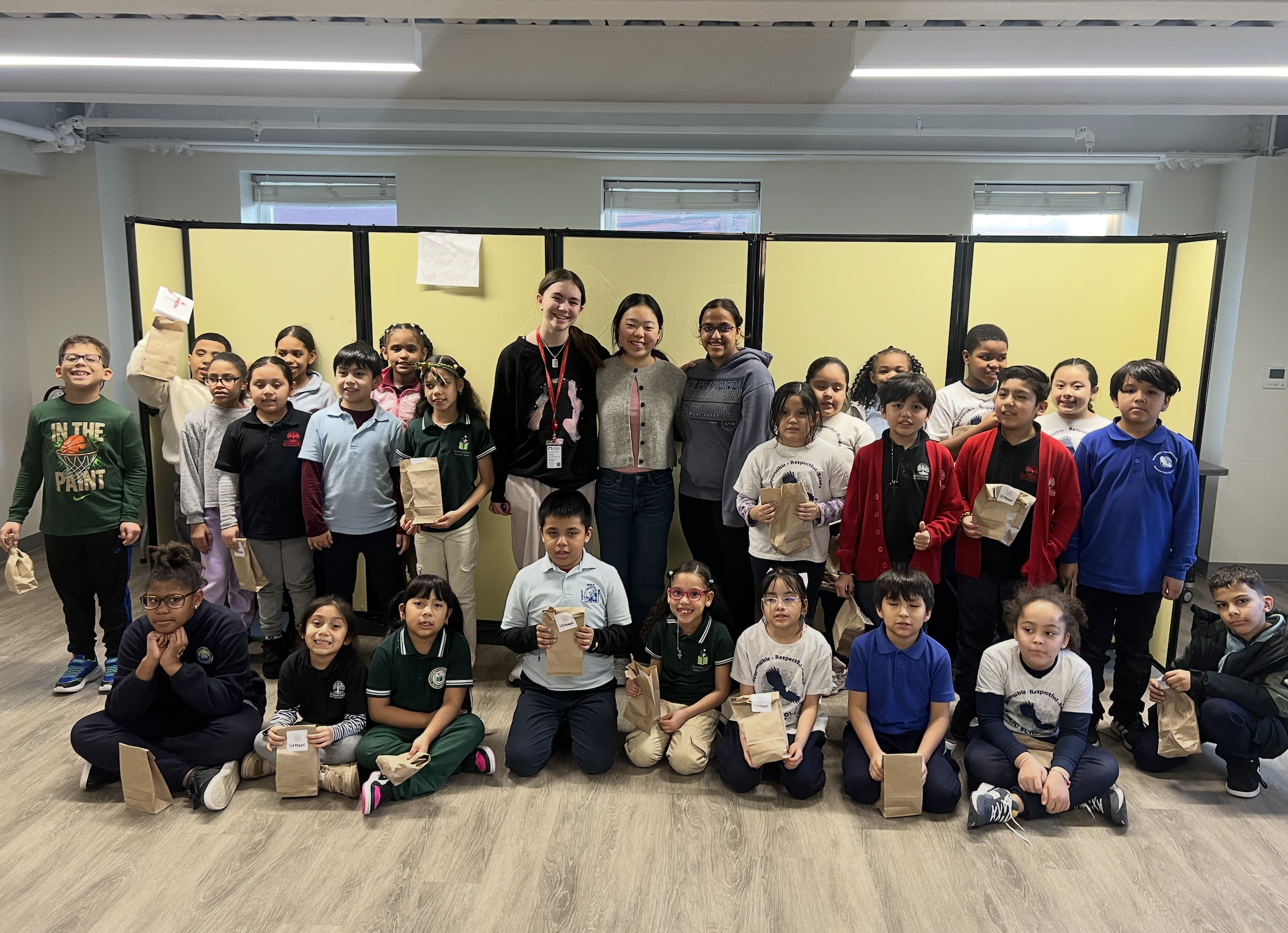 The Oasis after-school group with the STEMagic team, holding the kits they were given