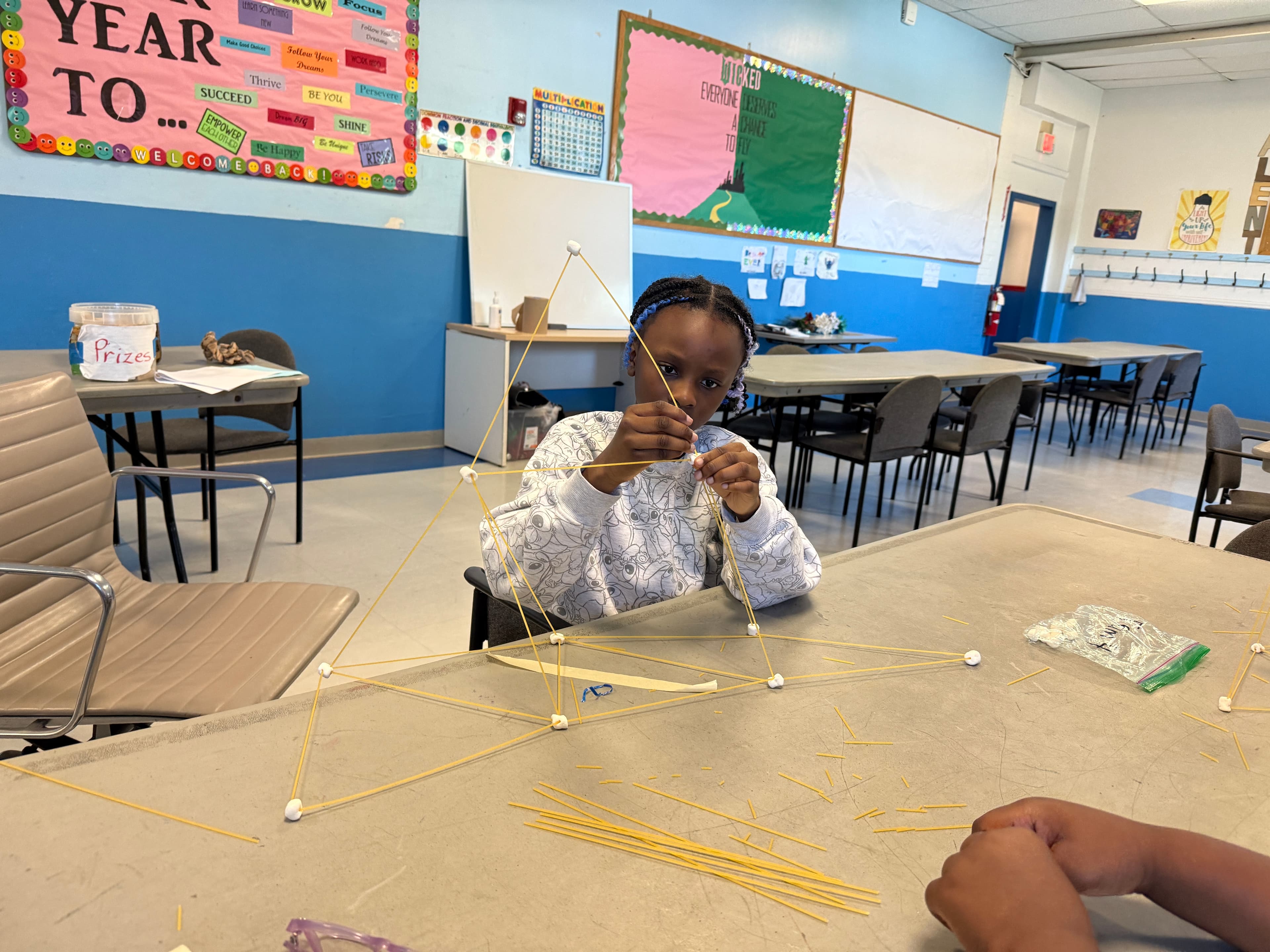 Students testing how much weight their spaghetti and marshmallow tower can hold